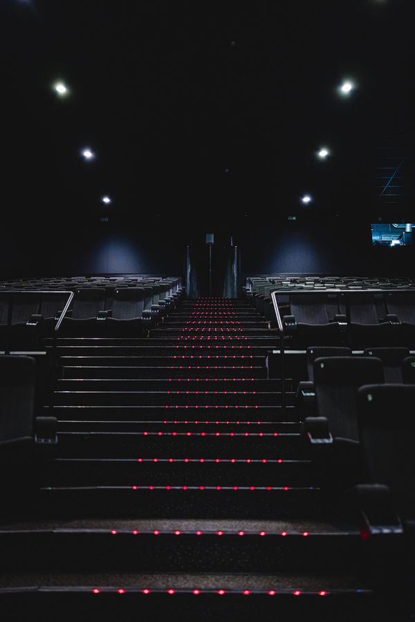 Auditorium steps in near darkness, red LED strips marking each tread between the seat rows.